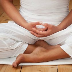 Meditator sitting with the hands on the lap.