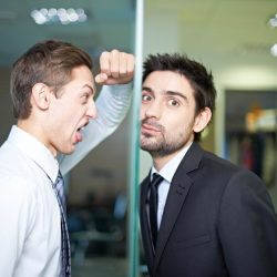 Businessman screaming at his colleague behind window