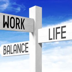 White wooden signpost/ crossroads sign with three arrows - "work", "life", "balance".